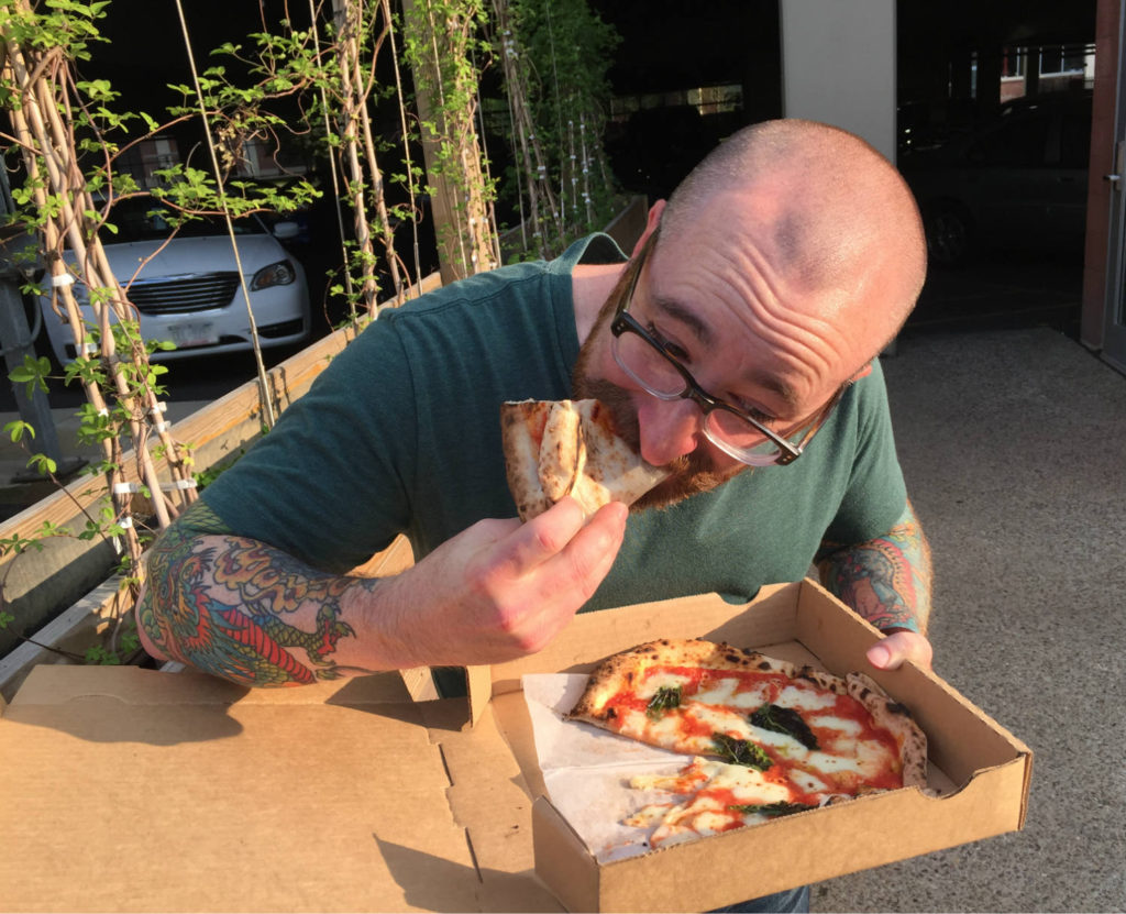 Chris Clemens eating O.G. Wood Fired Pizza in Buffalo, New York